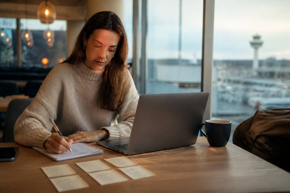Iemand die op een checklist let tijdens het vergelijken van vakanties op een laptop