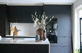 a vase of flowers sitting on a kitchen counter